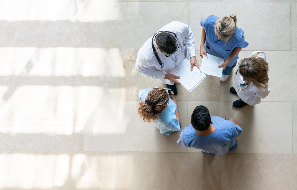 Stock photo of doctors standing in a circle in discussion